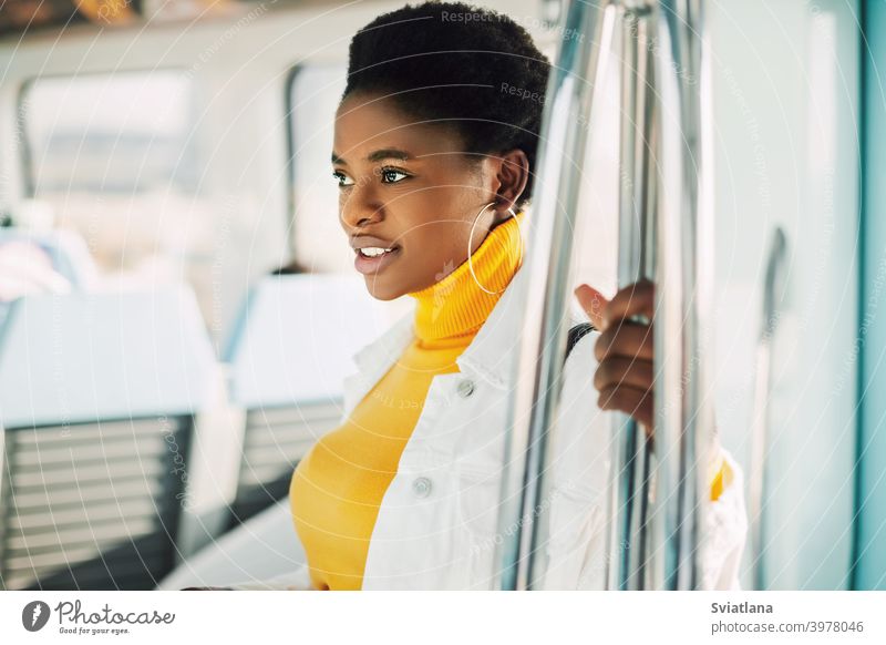 Porträt einer jungen afrikanischen Frau, die mit der U-Bahn fährt Afrikanisch Stehen Zug Lächeln im Inneren Passagier urban schwarze Frauen schwarze Millennials