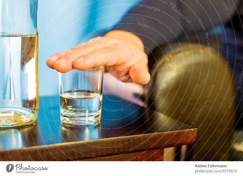Ein Mann hat seine Hand auf ein Glas gelegt, er möchte nichts trinken. Nahaufnahme Getränk Alkohol Schnaps Bar Tisch Party Nachtleben Club Lifestyle Restaurant