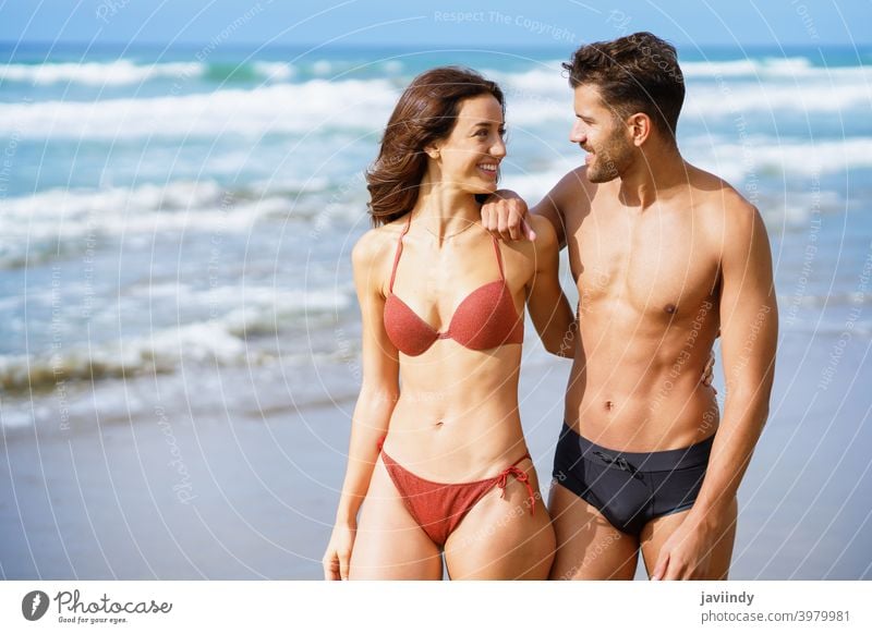Junges Paar von schönen sportlichen Körper zu Fuß zusammen am Strand Frau Mann Bikini Sommer Freizeit Lifestyle Mädchen Küste im Freien genießend Menschen weiß