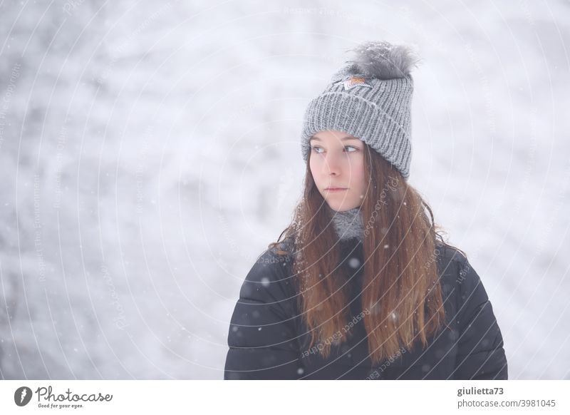 Teenager Mädchen mit melancholischem Blick draussen im verschneitem Winterwald Porträt Jugendliche Farbfoto Außenaufnahme Mütze Winterjacke Winterstimmung