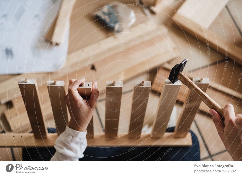 Nahaufnahme von jungen Frau Montage von Möbeln zu Hause arbeiten mit Hammer. DIY-Konzept. Ansicht von oben es selbst machen diy Zusammenbau heimwärts Kaukasier