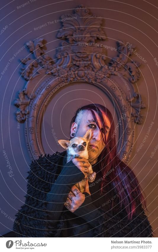 Gerahmtes Porträt eines exzentrischen Rockers mit seinem kleinen Hund. Er hat lange lila Haare. androgyn männlich schön jung Mann feminin Typ Nahaufnahme schwul