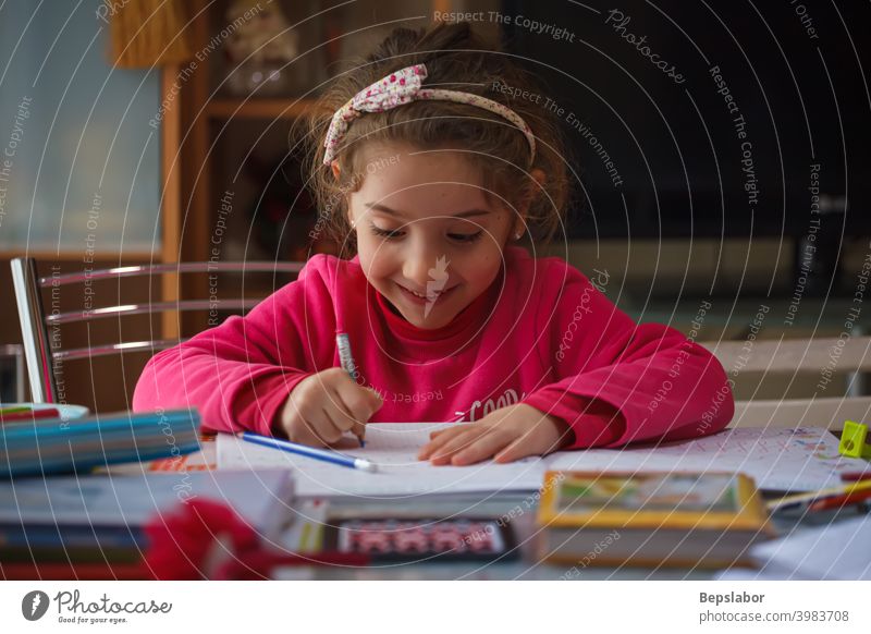 Lächelnde 6 Jahre altes Mädchen macht ihre Hausaufgaben Kind schreiben schreibend Tisch Fall Farben Füllfederhalter Lernen lernen Schulmädchen Schreibtisch
