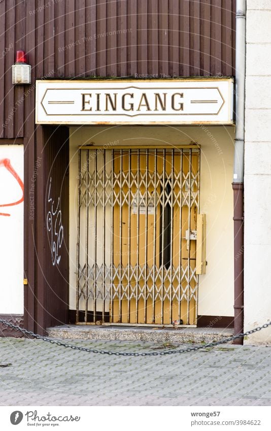 Die mit einem Scheerengitter gesicherte und verschlossene Eingangstür einer Spielothek Tür alt Holz Farbfoto geschlossen Außenaufnahme Menschenleer Tag