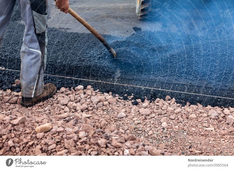 Schwerstarbeit bei der Asphaltierung einer neuen Straße bauarbeiter straße straßenbau schwer schwerindustrie bauarbeiten heiß warm teer asphalt baumaschine