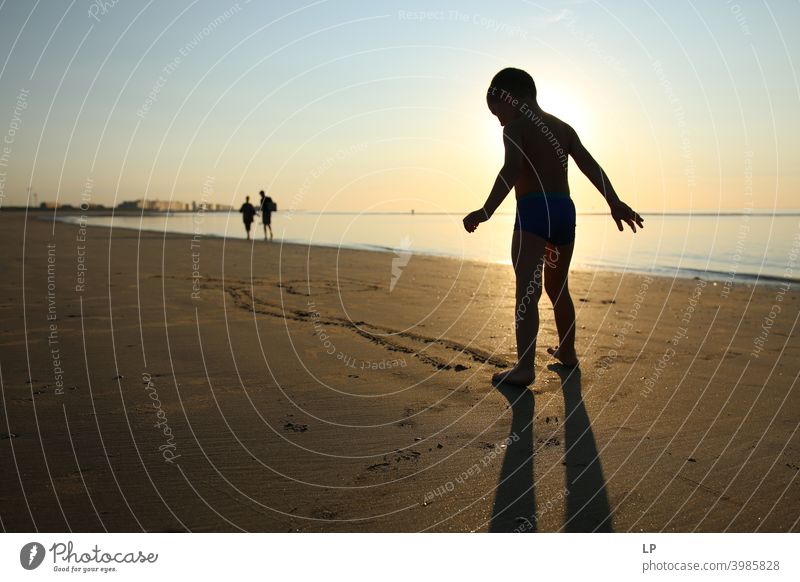 Silhouette des glücklichen Kindes am Ufer des Ozeans bei Sonnenuntergang Tanzen Glaube und Religion Hintergrund weitergeben Arme Hand Zufriedenheit