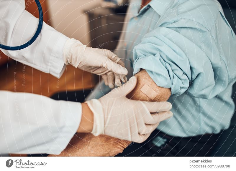 Arzt setzt ein Pflaster anstelle der Impfstoffinjektion bei einem älteren männlichen Patienten. Impfung gegen Covid-19 oder Coronavirus geduldig Person