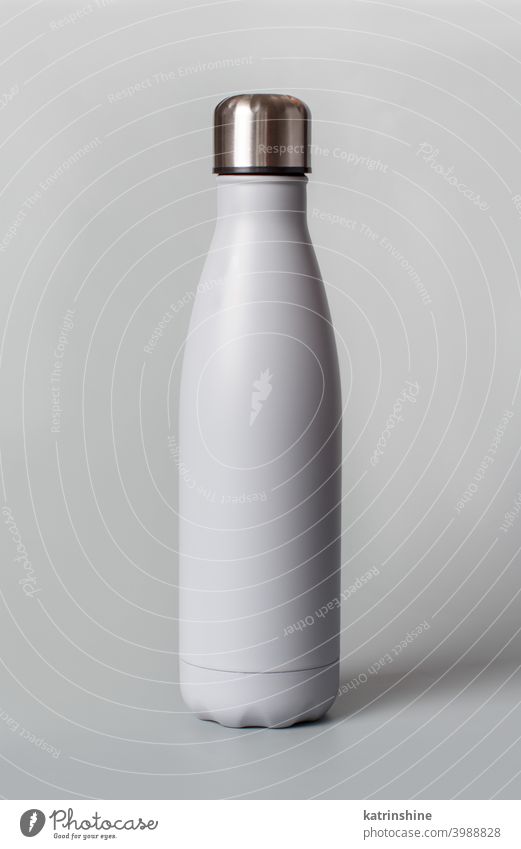 Graue wiederverwendbare Flasche auf grauem Hintergrund Monochrom Attrappe isoliert ökologisch Wasser Stahl Thermo Leichtmetall blanko abschließen Konzept