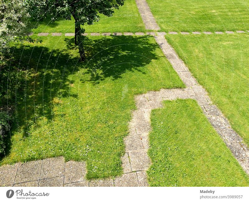 Gartenzwerge mit Steinplatten auf grünem Rasen in einem parkähnlichen Garten im Sommer bei Sonnenschein in Oerlinghausen bei Bielefeld im Teutoburger Wald in Ostwestfalen-Lippe