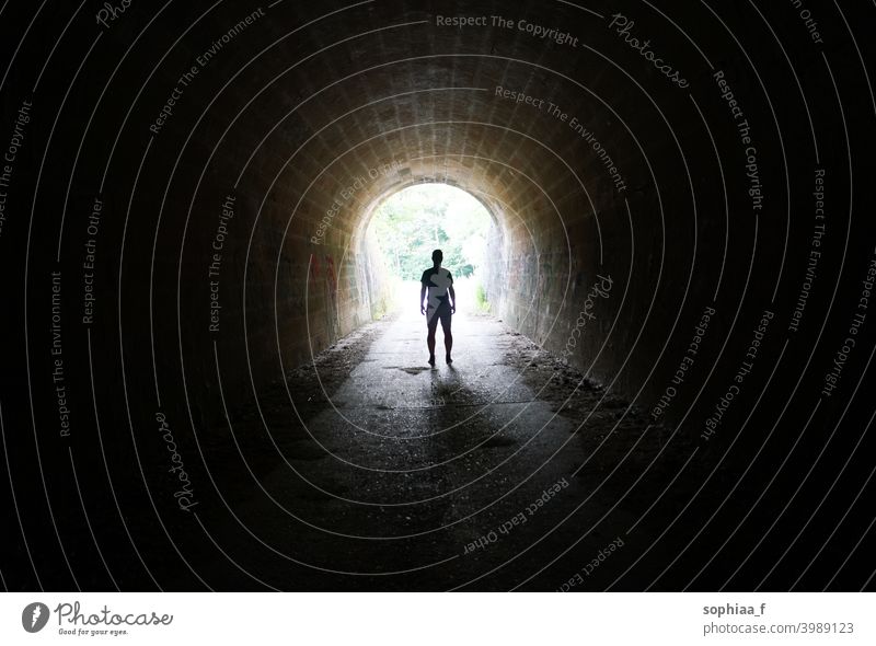 Escape the Darkness - Silhouette eines Mannes, der im Licht am Ende des Tunnels steht Stollen Einsamkeit Dunkelheit Depression Ausfahrt Zukunft Freiheit