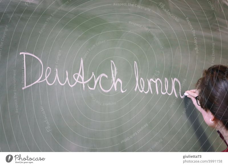 Deutsch lernen - Junge Lehrerin schreibt mit Kreide an die Tafel, Unterricht Zukunftsorientiert Eingliederung eingliedern Zusammenleben