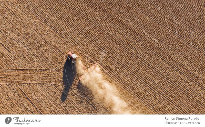 Drohnenansicht eines Traktors, der das Land bearbeitet Ansicht von oben Traktoren braun Landwirtschaft Bauernhof Landwirtschaftliche Geräte Bereiche Feld