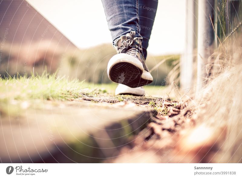 Fröhlich in Turnschuhen laufend auf einer Bahnschwelle Schuhe Sommer Spaziergang Fröhlichkeit Fuß Fußgänger Chucks Natur rennen Leichtigkeit Gute Laune draußen