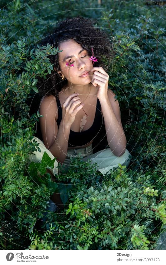 Outdoor-Mode Foto von schönen jungen Frau von Pflanzen umgeben Blume Schönheit Sommer lockig Mädchen Porträt Gesicht Behaarung Model niedlich Lifestyle