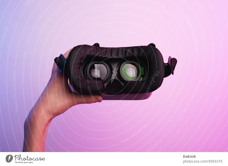 Virtual-Reality-Brille in der Hand auf buntem Hintergrund. Zukunftstechnologie, VR-Konzept Headset virtuell Realität weiß Schutzhelm Technik & Technologie Gerät