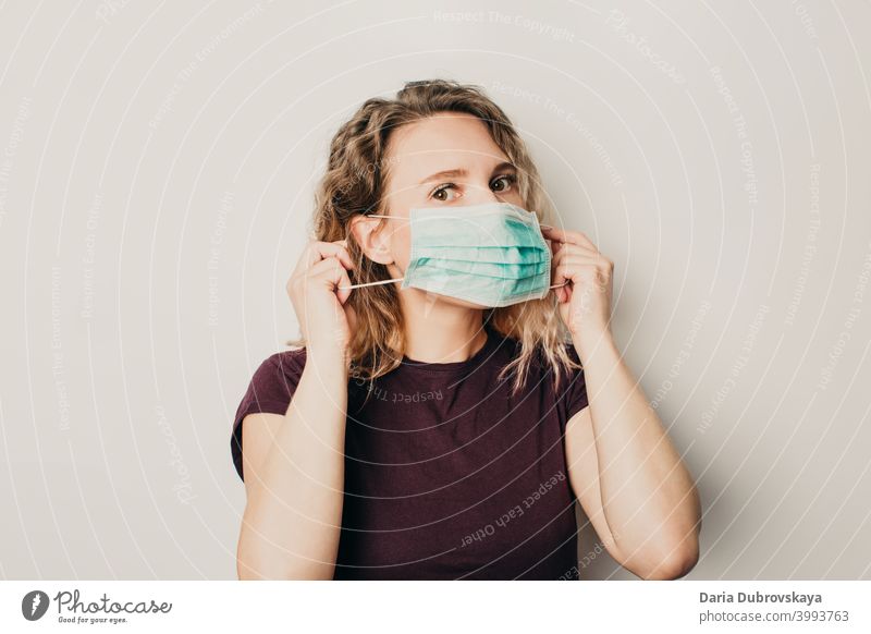 Mädchen setzt eine medizinische Maske auf Medizin Gesundheit Coronavirus Schutz Frau Pflege Person Hintergrund blau Arzt Operationsmaske Gesichtsmaske