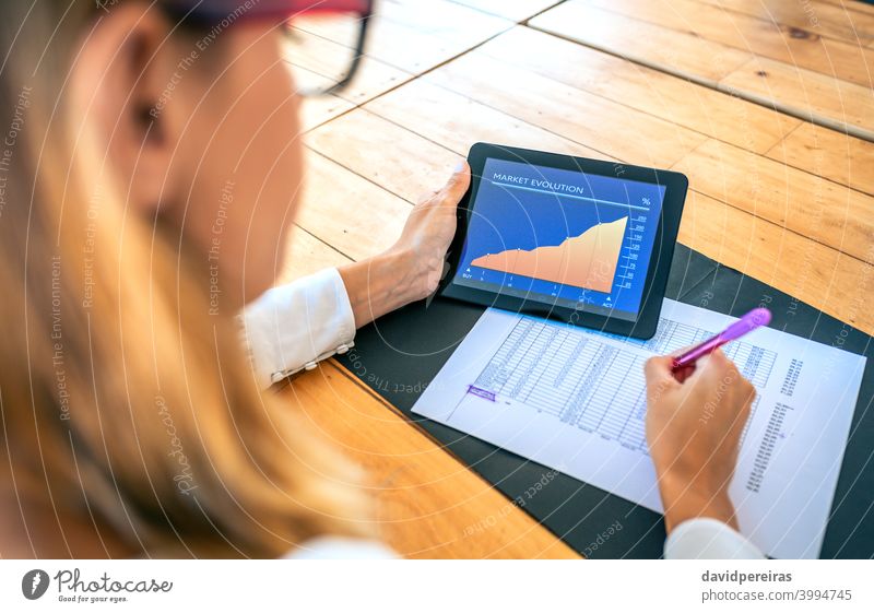 Geschäftsfrau analysiert die Marktentwicklung mit Tablet Investor Tablette Marktevolution Erfolg analysieren Dokumente alternative Geldanlage Bildschirm