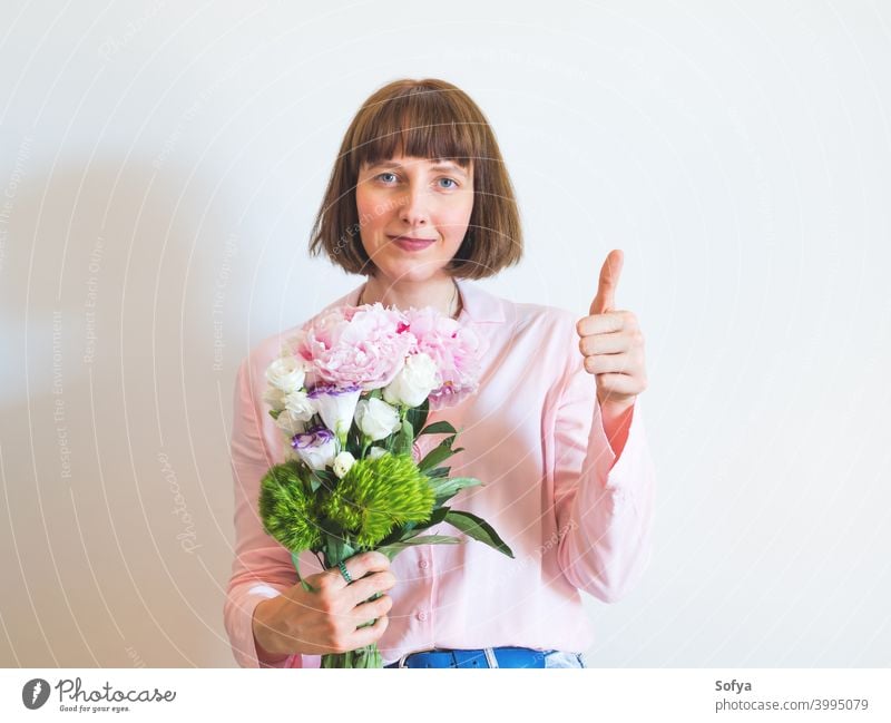 Frau in rosa hält schönen Blumenstrauß mit Hand Daumen nach oben Daumen hoch genehmigen ja abstützen lokal kaufen Werkstatt Beteiligung Mutter Tag Muttertag