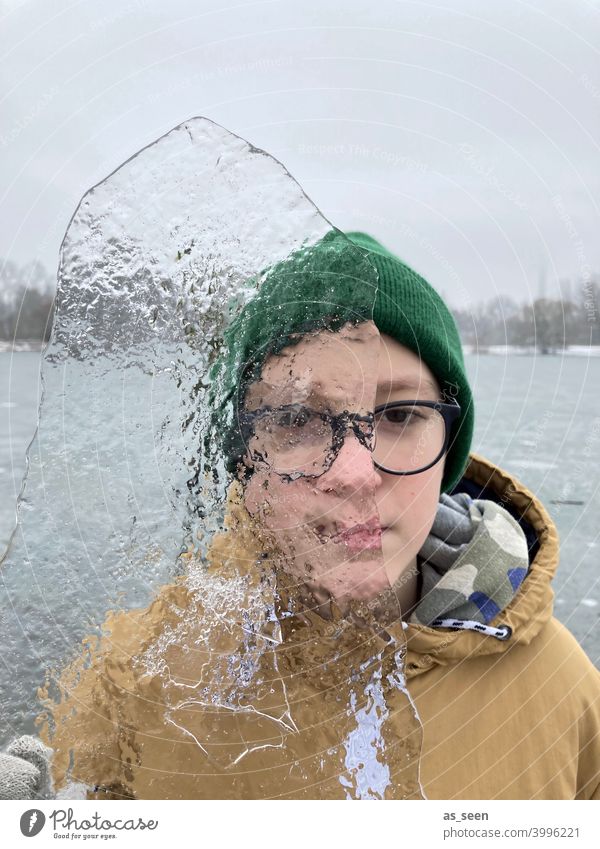 Durchblick Junge Eis durchsichtig kalt Winter Frost gefroren Schnee frieren Eiskristall Kristallstrukturen Natur Wasser Mütze See Handschuh Kindheit