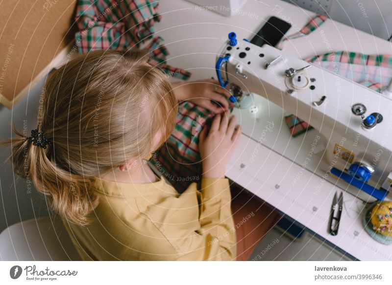 Draufsicht auf eine Frau bei der Arbeit mit der Nähmaschine in ihrer Werkstatt Maschine Nähen Gewebe Schneider Material Näherin Bekleidung Nadel Handwerk Faser