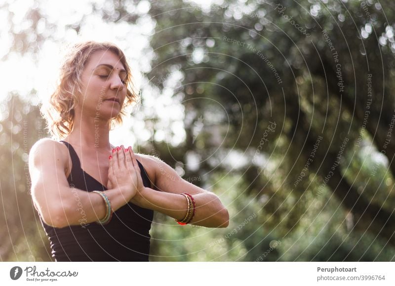 Schöne junge Frau meditiert in Yoga-Asana Padmasana - Lotus-Pose auf dem Holzdeck im Herbst Park Natur Erwachsener passen Gesundheit Lifestyle Lotos Unterlage