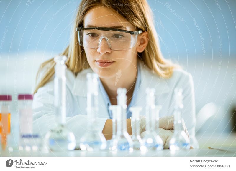 Weiblicher medizinischer oder wissenschaftlicher Forscher mit Blick auf einen Kolben mit Lösungen in einem Labor Frau Wissenschaftler forschen Experiment