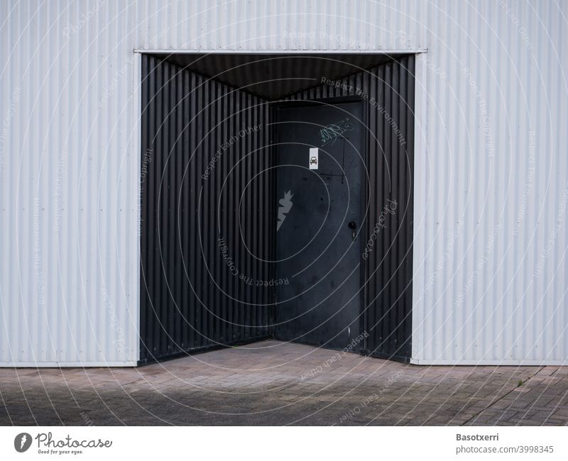 Schwarzer Garageneingang an modernem Wohnhaus aus weissem Wellblech Vitoria Baskenland Spanien spanisch Tiefgarage Hochhaus gewellt Wand Fassade Mauer weiß