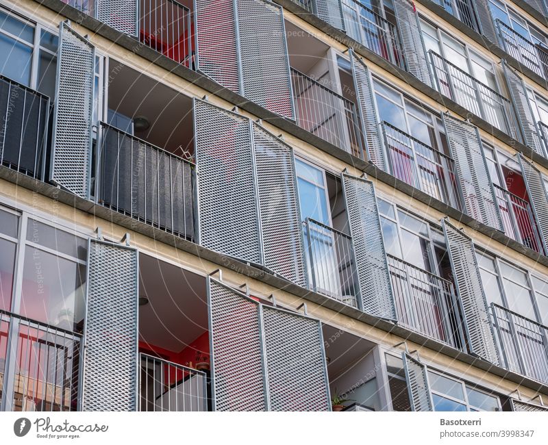 Detailansicht eines modernen Wohnhauses mit Balkons und klappbaren Läden aus Metall Wohnen Hochhaus rot Farbe Glas Laden Fensterladen Himmel Architektur Fassade