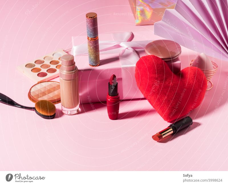 Kosmetik Schönheit Hintergrund mit rotem Herz auf rosa Make-up Produkte Lippenstift Valentinsgruß Fundament zusammenstellen Bürste Anzeige Schatten Mode