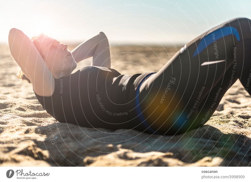 Frau mittleren Alters macht Übung am Strand Bauchmuskeln aktiv Erwachsener allein Athlet attraktiv Gleichgewicht schön blau Körper Energie passen Fitness