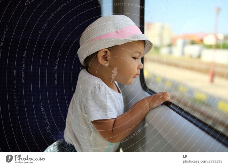 kleines Mädchen mit Hut, das aus einem Zugfenster schaut Wegsehen Oberkörper Kontrast Licht Textfreiraum unten Strukturen & Formen Muster abstrakt