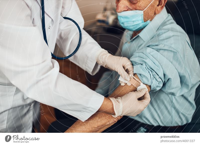 Arzt setzt ein Pflaster anstelle der Impfstoffinjektion bei einem älteren männlichen Patienten. Impfung gegen Covid-19 oder Coronavirus geduldig Person