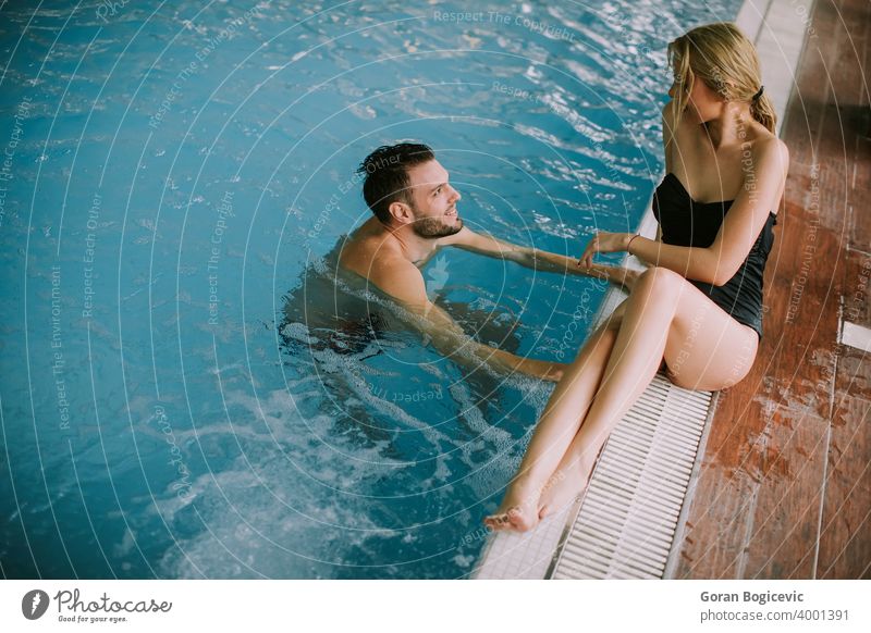 Junges Paar entspannt sich am Rande des Innenpools 20s Erwachsener attraktiv schön Schönheit Bikini Kaukasier heiter niedlich Saum genießen genießend Genuss