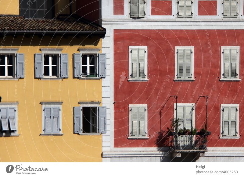 Fassaden,rot und gelb gestrichen mit weißen und grauen Fenstern und Fensterläden, ein Balkon Haus Gebäude farbig Fensterladen Architektur Außenaufnahme alt
