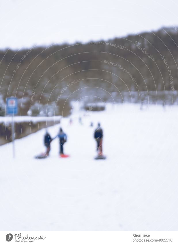 Kinder im Dorf beim Schlittenfahren unscharf fotografiert schlittenfahren Winter Schnee kalt Natur weiß Rodeln Freude Farbfoto Außenaufnahme Freizeit & Hobby