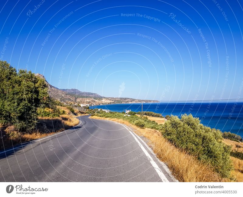 Küstenlinie und eine kurvenreiche Straße in Keratokampos, Kreta Asphalt Bucht Strand Cloud Ökoregion Fernstraße Gras grün Autobahn Horizont Insel See Landschaft