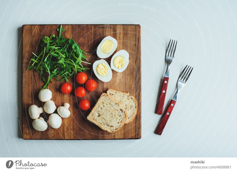 Zutaten für die Zubereitung von vegetarischer Bruschetta mit Kirschtomaten, Ruccola, Pilzen und gekochten Eiern. Gesunde Ernährung Frühstück Tomate Zuprosten