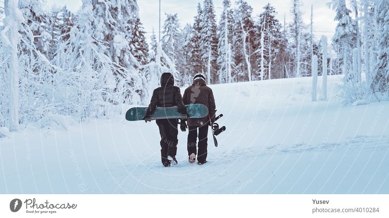 WEB-Banner-Format. Zwei Freunde Snowboarder sind zu Fuß durch den Winterwald. Snowboarden im Wald in den Bergen. Backcoutry oder Freeride-Stil. Lebensstil.