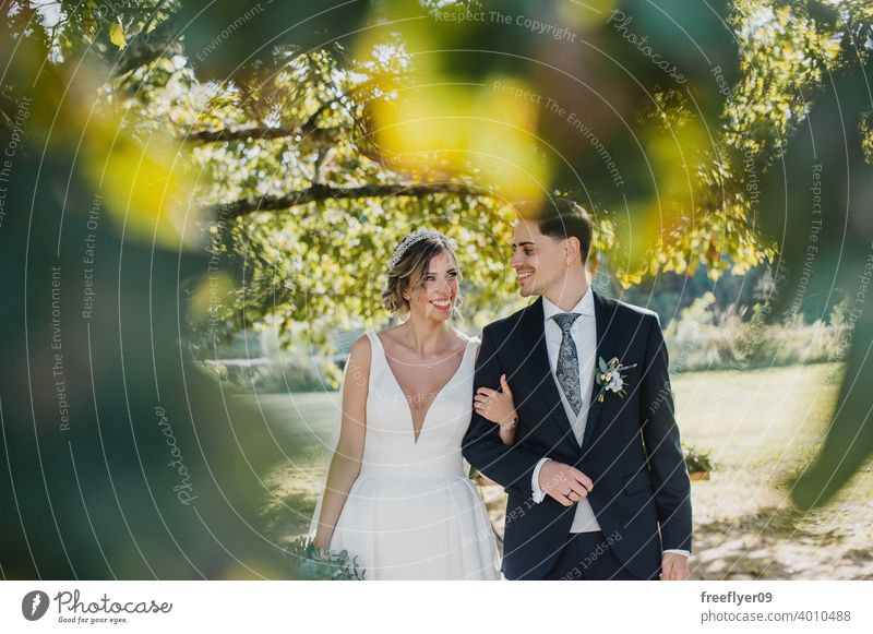 Junges Paar schaut sich an ihrem Hochzeitstag an Heirat Engagement Braut Menschen jung attraktiv Textfreiraum striegeln Baum Natur Außenseite Sonnenlicht Sommer