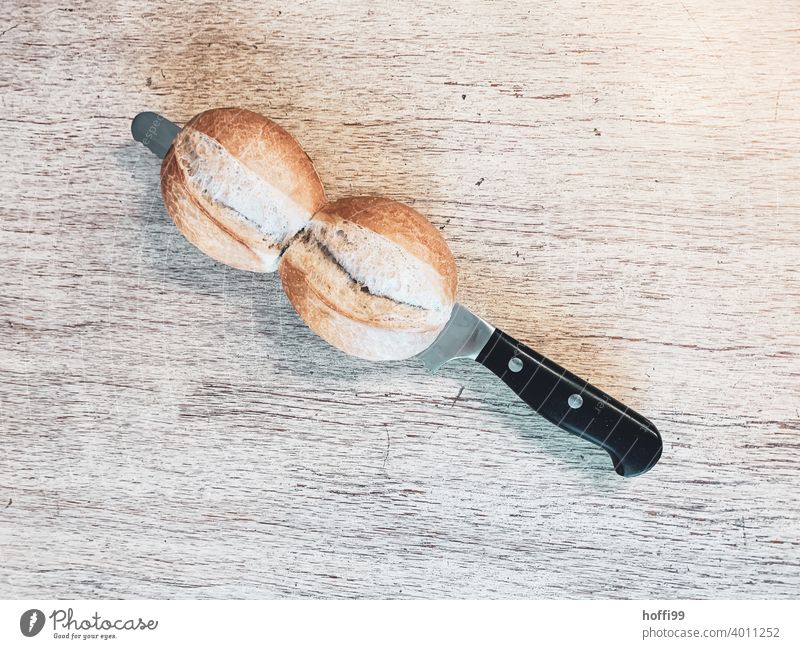 zwei Brötchen mit Messer im Anschnitt aufschneiden Frühstück lecker Bioprodukte Ernährung Brot minimalistisch Backwaren brotmesser Teigwaren frisch