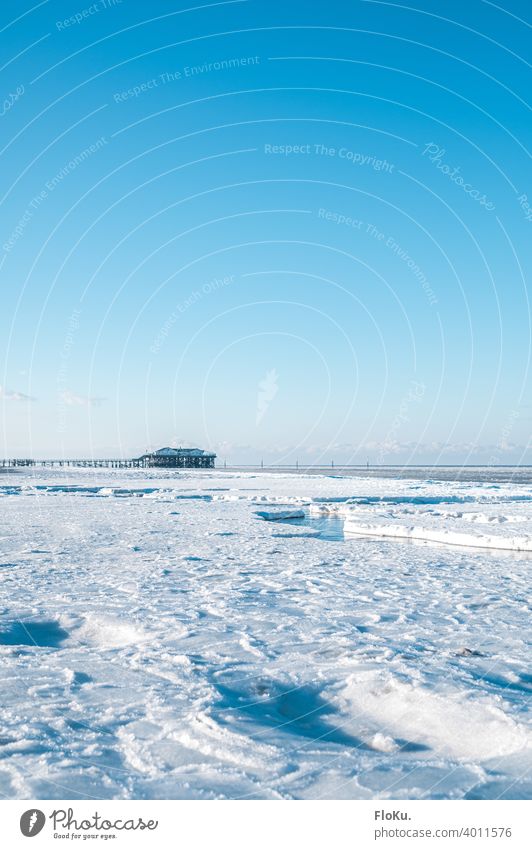 Winter mit viel Eis in Sankt Peter-Ording Strand Nordsee Küste Meer Einsamkeit Sonne Wellen Sand Wasser kalt Himmel blau Ebbe Ferne Horizont