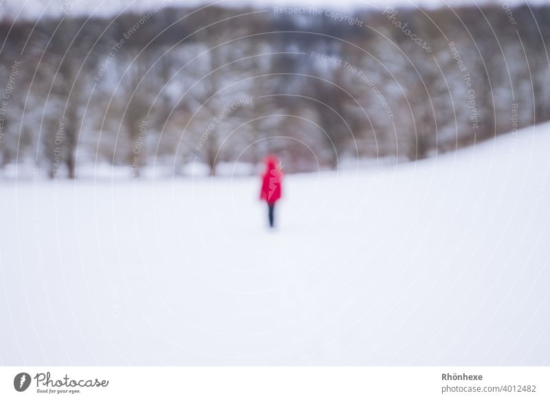 Ein "Geist"  in roter Jacke beim Winterspaziergang unscharf fotografiert Unschärfe Mensch Farbfoto Außenaufnahme Tag Schnee weiß Winterlicht Landschaft Umwelt