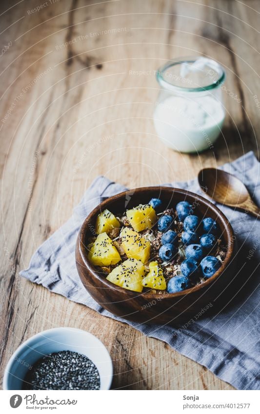 Gesundes Frühstück mit Müsli und Obst Haferflocken Heidelbeere Ananas Früstückstisch Gesunde Ernährung superfood Foodfotografie Tisch Holz rustikal Diät