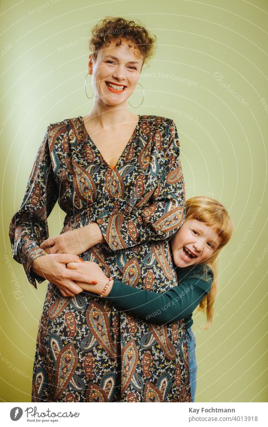 Porträt einer alleinerziehenden Mutter und ihrer vorpubertären Tochter vor grünem Hintergrund Erwachsener Pflege Kaukasier heiter Kind Kindheit niedlich Emotion