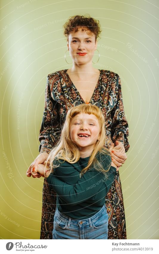 Porträt einer alleinerziehenden Mutter und ihrer vorpubertären Tochter vor grünem Hintergrund Erwachsener Pflege Kaukasier heiter Kind Kindheit niedlich Emotion