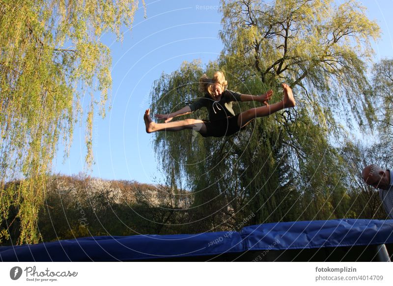 Teenager springt auf einem Trampolin hüpfen Sprung Sprungkraft turnen akrobatisch springen Fitness Freude beweglich Jugendliche Bewegung Lebensfreude Sport