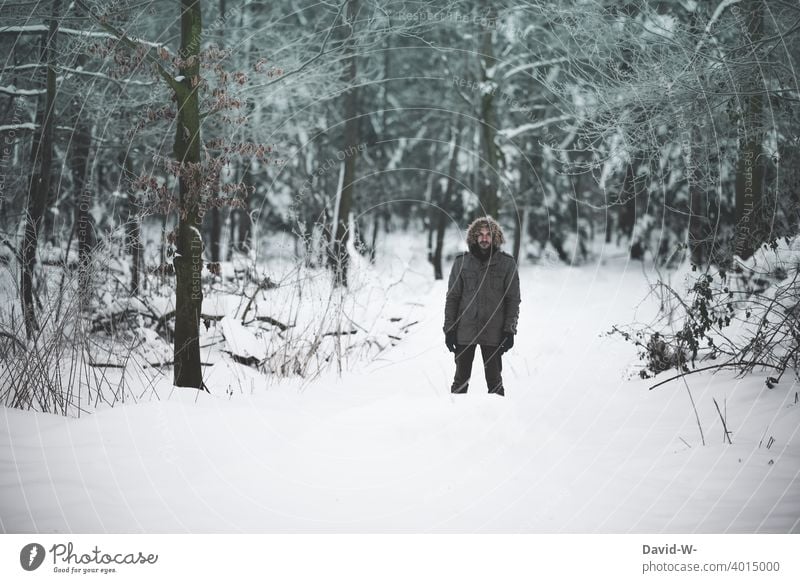 Mann steht bei eisiger Kälte in einem verschneiten Wald winter kalt Schnee kühl kälte Winterstimmung Wintertag wandern winterlich Winterwald frieren Dezember