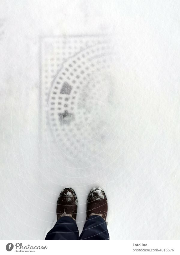 Fotoline bremste, als sie den schneebedeckten Gullideckel vor ihren Füßen sah. Das Muster zeichnete sich noch ab. Das fand sie toll. Schnee Winter kalt frostig