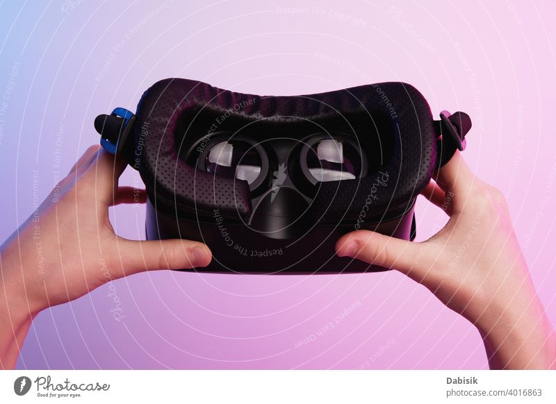 Virtual-Reality-Brille in der Hand auf buntem Hintergrund. Zukunftstechnologie, VR-Konzept Headset virtuell Realität weiß Schutzhelm Technik & Technologie Gerät