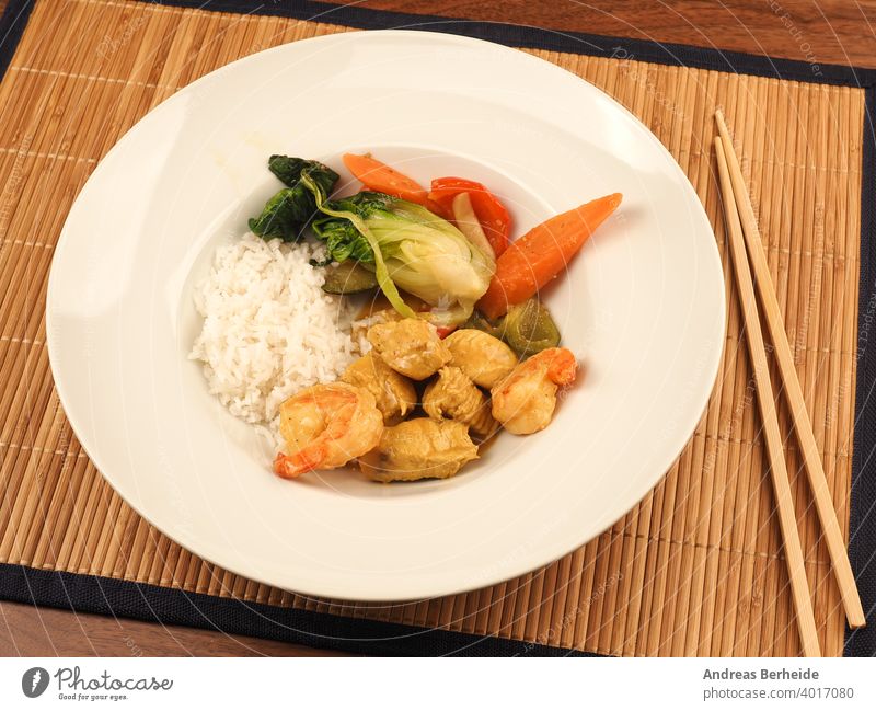 Rotes Thai-Curry mit Huhn und Garnelen mit gebratenem Gemüse und Reis Würzig Hähnchen Chili geschmackvoll Essen zubereiten Küche Gesundheit Salatbeilage hölzern